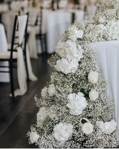 white flowers and baby's breath decorate the centerpieces at a wedding reception