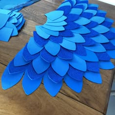 blue paper cut outs sitting on top of a wooden table