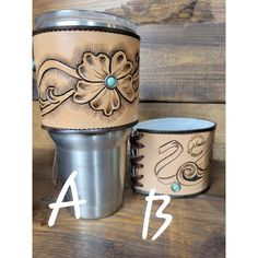 two leather cups sitting next to each other on top of a wooden table with numbers