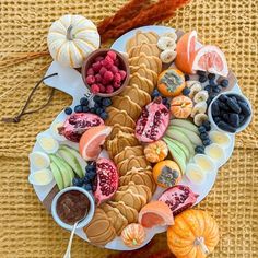 a platter filled with fruit and veggies on top of a table