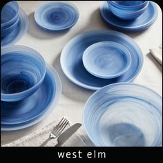 blue plates and silverware on a white table cloth