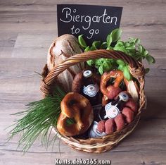 a basket filled with assorted pretzels, beer and other foods sitting on top of a wooden floor