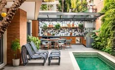 an outdoor kitchen and dining area next to a swimming pool