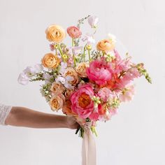 a person holding a bouquet of flowers in their hand