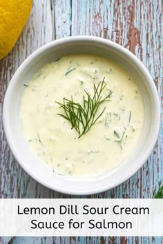 lemon dill sour cream sauce in a white bowl on a wooden table with fresh herbs