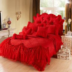 a red bed with ruffled bedspread and pillows