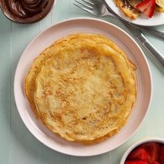 a plate with some food on it next to two bowls of strawberries and chocolate