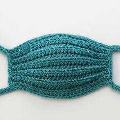 a crocheted fish is shown on a white surface with blue yarn around it