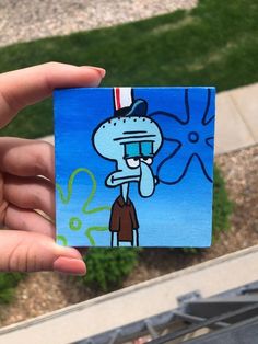 someone holding up a piece of paper with an image of spongebob on it