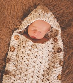 a newborn baby wrapped in a crochet blanket