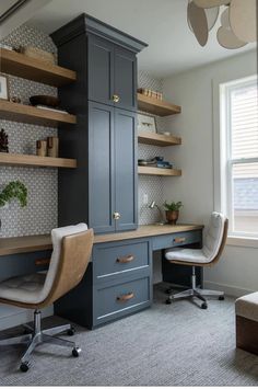 a home office with built in shelving units and desks, along with two chairs