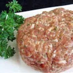 a piece of meat sitting on top of a white cutting board next to parsley