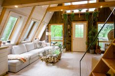 a living room filled with lots of furniture next to a window covered in wood planks