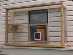 a chicken coop with a cat door and bird feeder on the side of a house