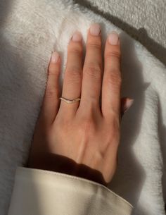 a woman's hand on top of a white blanket