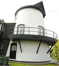 a large white building with a black roof and balcony on the top of it's side