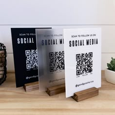 three social media brochures sitting on top of a wooden table next to a potted plant