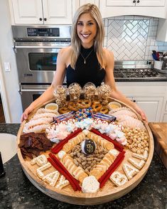 a woman standing in front of a large platter of food