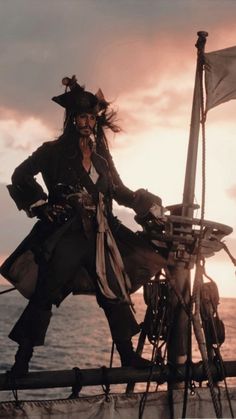 a man in pirate costume standing on the deck of a ship