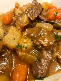 a close up of a plate of food with meat and carrots on the side