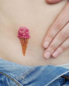 a woman's stomach with an ice cream cone tattoo on it