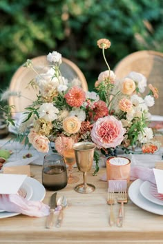 the table is set with flowers and silverware