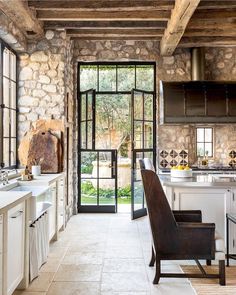 an open kitchen with stone walls and doors