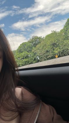 a woman sitting in the passenger seat of a car holding her cell phone up to her ear