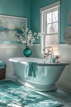 a bath tub sitting next to a window with flowers in the vase on top of it