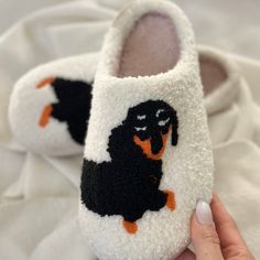 someone is holding their slippers with a dog on them