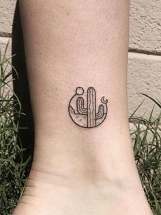 a small tattoo on the ankle of a woman with a cactus and moon in it