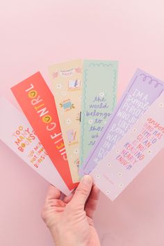 someone is holding five colorful bookmarks in their left hand, with the words i love you written on them