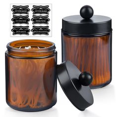 an orange jar with black lid and some stickers on the side next to it