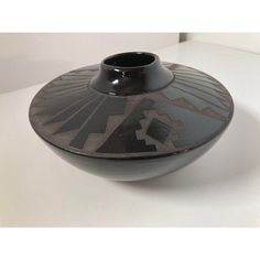 a black vase sitting on top of a white table