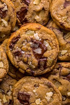 chocolate chip cookies piled on top of each other with crumbled nuts in the middle