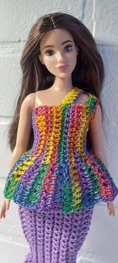 a doll is wearing a colorful crocheted dress