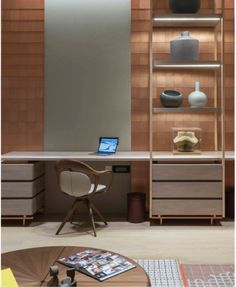 a desk with a laptop on top of it next to a book shelf and shelves