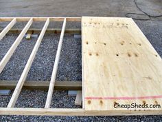 an unfinished bed frame sitting on top of gravel