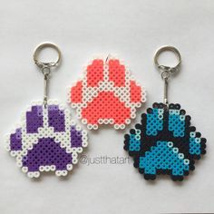 three keychains made to look like pixel video game characters, each with different colors and sizes