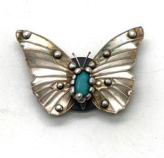 a brooch with a butterfly shaped design on it