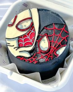 a spiderman cake in a box on a table