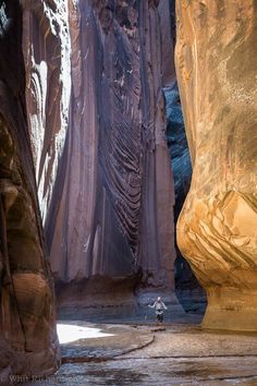 a person standing in the middle of a canyon