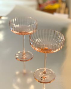 three wine goblets sitting on top of a table next to eachother