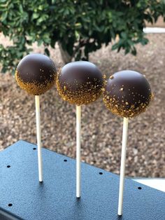 three chocolate covered cake pops sitting on top of a table