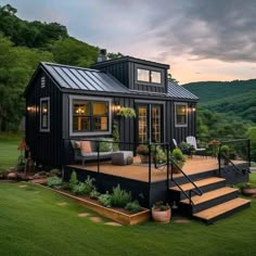 a small black house with stairs leading up to it