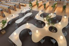 the interior of a library with many tables and bookshelves filled with plant life