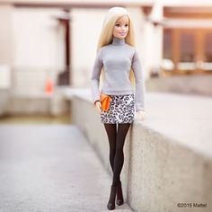 the barbie doll is wearing a gray sweater and leopard print skirt, but she's not dressed up