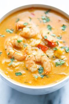 a white bowl filled with soup and shrimp on top of it's crusts