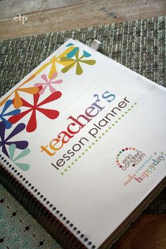 a notebook with the words teacher's lesson planner on it sitting on a table