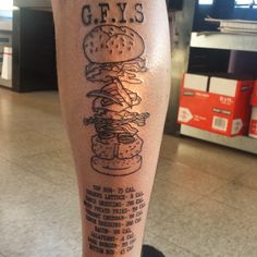 a man's leg with a tattoo that reads geys on it and a hamburger